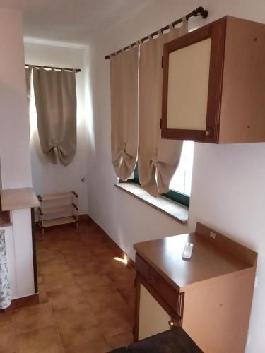 ein kleines Zimmer mit einem Tisch und zwei Fenstern in der Unterkunft Le 5 querce in Nettuno