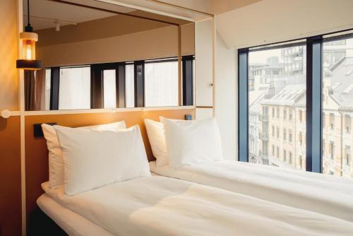 zwei Betten in einem Hotelzimmer mit Fenster in der Unterkunft Scandic Go, Grensen 20 in Oslo