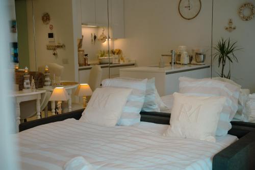 a bed with white sheets and pillows in a room at The White coast studio in Nieuwpoort