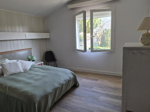 a bedroom with a bed and a window at le coulinet in Andernos-les-Bains