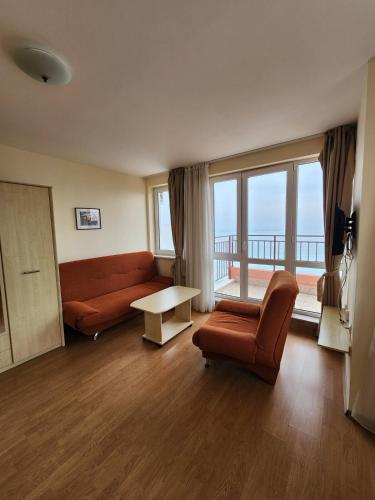a living room with a couch and a table at Stunning Beach View Apartment in Ravda