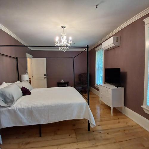 a bedroom with a large bed and a chandelier at Cranberry Moon Inn in Bala
