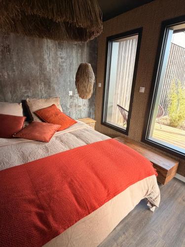 a bedroom with a large bed with red pillows at Refuge des Dunes in Marck