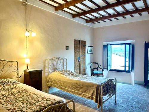 a bedroom with two beds and a window at Palazzo Bruschi in Pergola