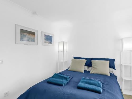 a blue bed with two pillows on top of it at Central Sherborne in Sherborne