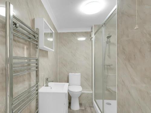 a bathroom with a toilet and a shower and a sink at Central Sherborne in Sherborne
