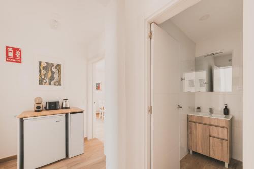 a white kitchen with a counter and a sink at Alojamiento en Santa Eugenia A in Madrid