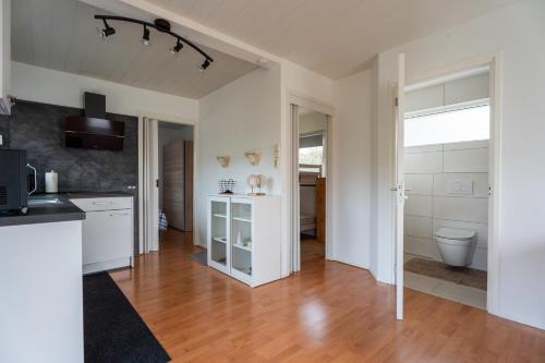 a kitchen with a sink and a toilet in a room at Zonneschijn, bungalow op vakantiepark bij zee in Baarland