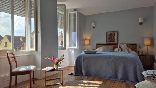 a bedroom with a bed and two windows at Burgundy Heritage Collection - Refuge d'Exception au cœur d'Autun in Autun