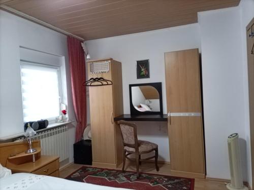 a bedroom with a bed and a chair and a mirror at Zimmer mit Doppelbett in Zagreb