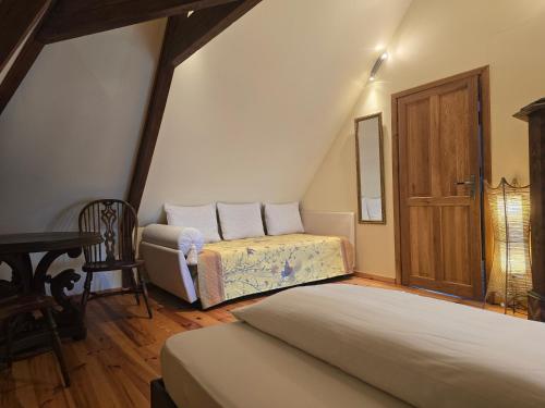 a attic bedroom with two beds and a chair at Apartment in a Chateau with Park in Trébry