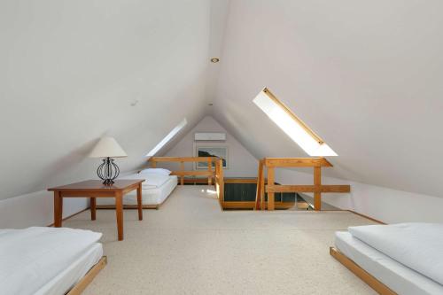 a attic room with white furniture and a staircase at Plac Neptuna Bright Studio with Balcony by Noclegi Renters in Międzyzdroje