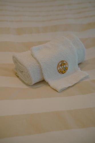 a towel on a bed with a button on it at The White coast studio in Nieuwpoort