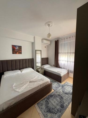 a bedroom with two beds and a window at Kapo Apartments in Gjirokastër