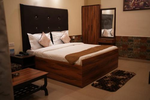 a bedroom with a large bed and a table at New Orange Tree Classic Fall in Mussoorie with pool & parking in Mussoorie
