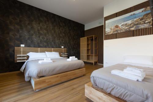 a bedroom with two beds and a wall at Costa d'Abruzzo - Casa Vacanza in Montesilvano