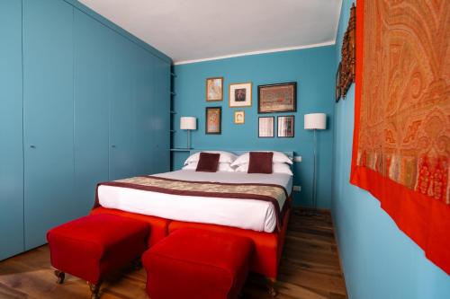 a bedroom with blue walls and a bed with red seats at Paruta Jazz Apartment in Venice