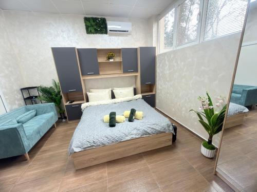 a bedroom with a bed and a blue couch at Cozy Corner 41 in Ruse