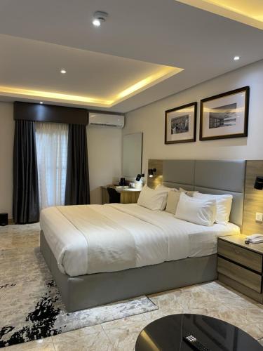 ein Hotelzimmer mit einem großen Bett und einem Schreibtisch in der Unterkunft Ringruby Hotel, Oladipo Bateye in Lagos