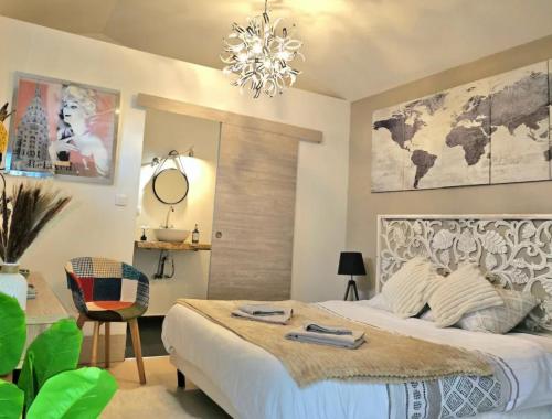 a bedroom with a large bed and a chandelier at Chambre Belvédère in Porto-Vecchio