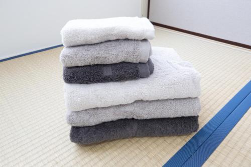 a stack of towels sitting on the floor at Blue moon house miyama in Funabashi