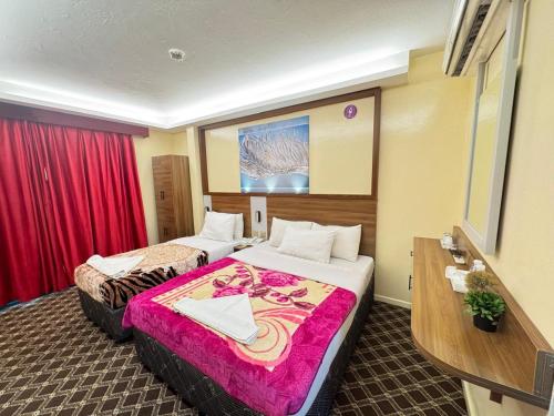 a hotel room with two beds and a sink at Naif Palace Hotel in Dubai