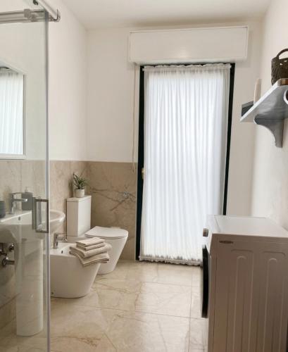 a bathroom with a toilet and a sink and a shower at Domu Bella in Decimomannu