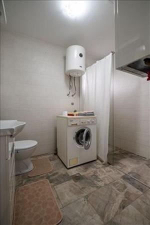a bathroom with a washing machine and a toilet at Super Vila in Jajinci