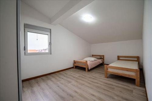 a bedroom with a bed and a window in a attic at Super Vila in Jajinci