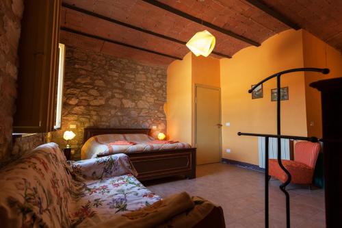 een slaapkamer met een bed en een bank in een kamer bij Agriturismo La Valentina Nuova in Talamone