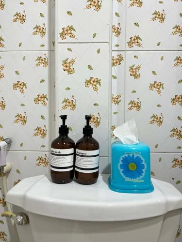 two bottles of soap sitting on top of a toilet at Yao noi cozy home in Ko Yao Noi