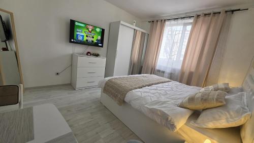 a bedroom with a bed and a flat screen tv at Apartament Severin Caple in Drobeta-Turnu Severin