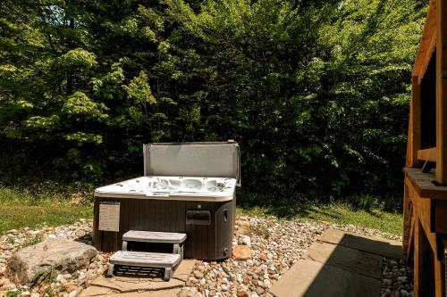 a stove sitting in a yard next to a bush at Fiddler Lake Resort - Deer 9 in Mille-Isles