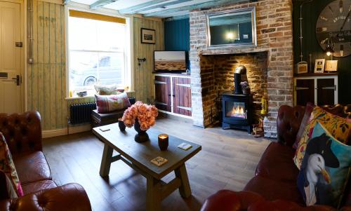 a living room with a fireplace and a table at Boutique Fisherman's Cottage in Old Town in Scarborough
