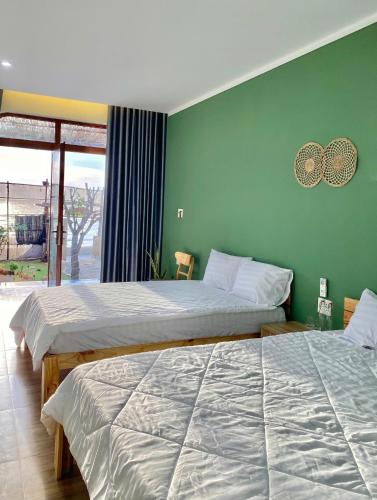 two beds in a room with green walls at Xóm Chài Homestay in Thôn Sơn Hải