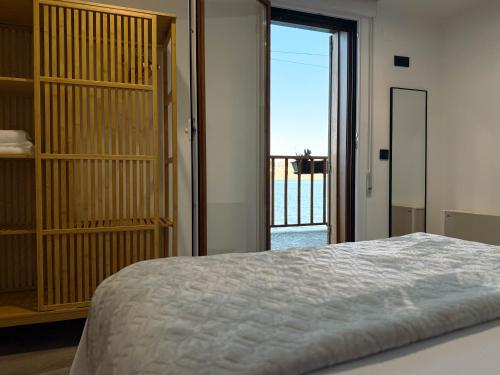 a bedroom with a bed and a large window at Casa da Escola in Combarro