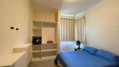 a bedroom with a blue bed and a window at Mirante do Morro in Alto Paraíso de Goiás
