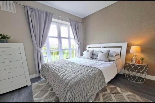 a bedroom with a bed and a large window at 2 Bedr Portmarnock Dublin Suburb in Dublin