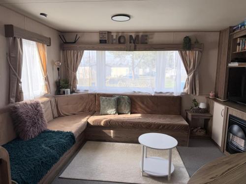 a living room with a couch and a window at Caravan Turnberry 2 , Seton Sands, Wifi in Port Seton