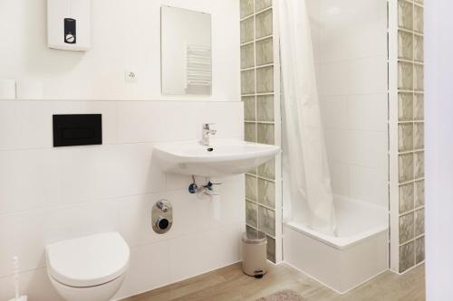 a white bathroom with a toilet and a sink at Monteurzimmer Oldenburg i.H. – Top Lage in Oldenburg in Holstein