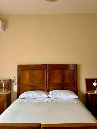 a bed with a wooden headboard in a bedroom at Villa Ada in Monsummano Terme