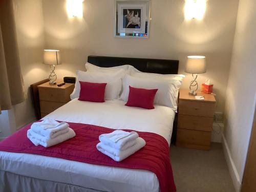 a bedroom with a bed with two towels on it at Edenbank Hotel in Dumfries