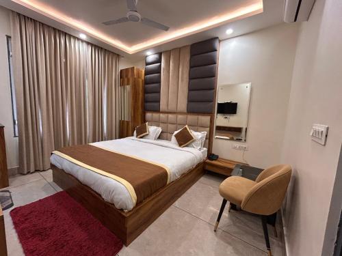 a bedroom with a large bed and a chair at Garden view by Midtown in Katra