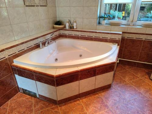 a large tub in a bathroom with a window at u koupaliste in Mimoň