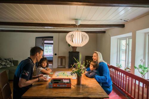 a family sitting at a table in a dining room at Alunbruket B & B in Brösarp