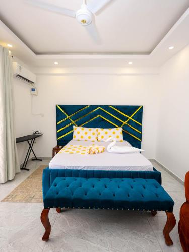 a bedroom with a blue bed with yellow pillows at Giannas stays 3B in Mombasa