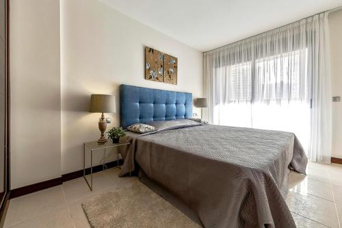 a bedroom with a large bed with a blue headboard at Doble Playa in Playa Paraiso