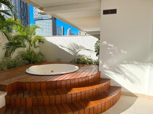 a bath tub sitting on top of a wooden deck at Flat Lounge 22 Setor Oeste in Goiânia