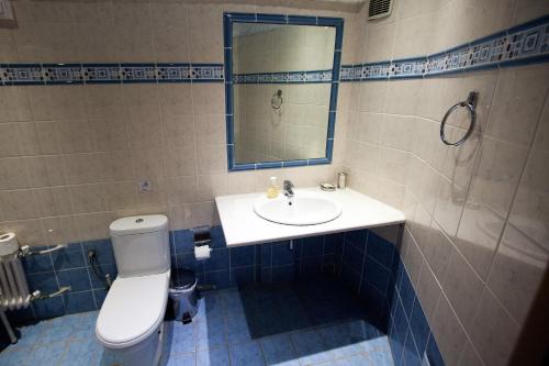 a bathroom with a toilet and a sink and a mirror at Thomas Beach Hotel in Nea Makri