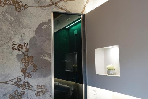 a mirror in a bathroom with a vase of flowers at Gio Leo Guest House in Lesa